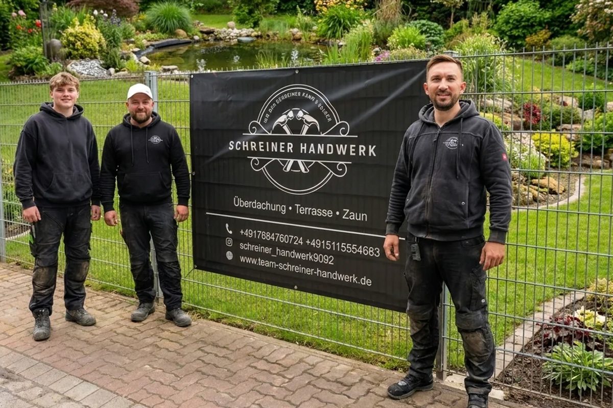 Das Team von Schreiner Handwerk vor dem Firmenbanner